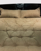 Cushioned self-inflating car travel bed for folded rear seats