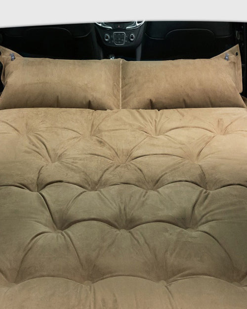 Cushioned self-inflating car travel bed for folded rear seats